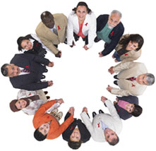 Photo prise du dessus d'un groupe de personnes se donnant la main, formant un cercle et levant la tête vers le photographe