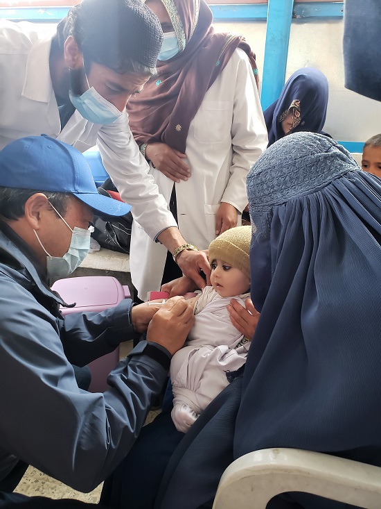 WHO Representative in Afghanistan Dr Luo Dapeng joins the measles vaccination campaign and vaccinates a child in Malek Mohammad Khan District Hospital in Wardak Province, Afghanistan, on 13 March 2022