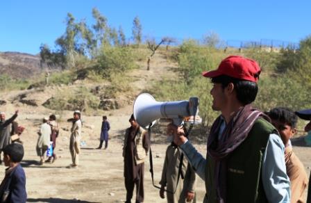 13._Vaccinator_Jawad_calls_out_for_children_under_the_age_of_10_at_the_Torkham_border_to_get_a_polio_vaccination_if_they_have_not_yet_received_it_from_teams_climbing_into_trucks