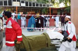 Health workers carry an injured man on a stretcher