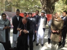 Dr Rik Peeperkorn, WHO Representative for Afghanistan, administers an oral polio vaccine to a child as part of Afghanistan's polio eradication campaign. He is in the presence of President Hamid Karzai, his two Vice Presidents, H.E. the Minister of Health of Afghanistan and other health officials