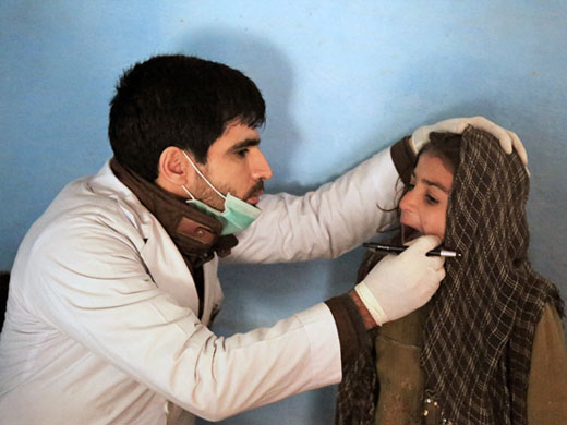 Credit: WHO Afghanistan/S.Ramo Dr Saleh Ahmad checks 7-year-old Nasima’s teeth at a mobile clinic at the Pul-e-Company IDP camp. Nasima’s family fled the conflict in Kunduz a year ago and they have been living in the camp since then. “This is a very busy clinic, I see on average 100 patients a day,” Dr Saleh says. “The main health problems are respiratory infections, diarrhoea, eye infections. People here also suffer a lot from mental health issues and anxiety. These cases we sometimes refer outside to bigger government hospitals that have the capacity to provide treatment, but it is not always easy for IDPs to access services there.”