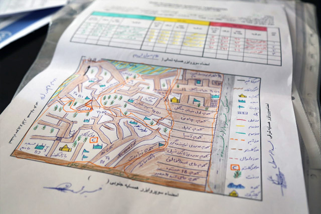 Before each vaccination campaign, polio programme draws detailed maps of where each team will head. These maps are called “microplans”, and they show streets, landmarks and each house where vaccinators need to visit during the campaign days. Dr Zalmai Ataie and Dr Esmaiel Sadiqi examine a map in the Herat regional office.