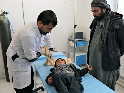 Credit: WHO Afghanistan/S.Ramo Nurse Mohammad Massoud examines 2-year-old Abdullah who fractured his leg when he fell from a roof over a month ago. Abdullah was treated at the trauma care unit and his fractures have healed well. Nurse Mohammad has worked at the unit for over 6 months. “My favourite part of this job is to see the patients doing well and going back to their homes. I like serving the Afghan people. This makes me very happy,” he says.