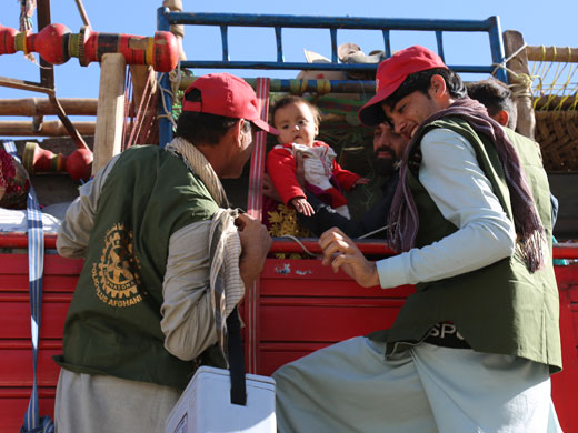 Photo credit: WHO Afghanistan/S.RamoPolio vaccinators climb up a truck to vaccinate a child at the Torkham border in Nangarhar, the busiest border crossing in Afghanistan. This family just arrived from Pakistan with all their possessions packed in the truck – food, firewood for the winter, clothes, furniture and their cow. In October, over 31 000 returnee children were given the oral polio vaccine (OPV) and over 12 000 received injectable inactivated polio vaccines (IPV) and measles vaccines with WHO support. At this first point of entry at Torkham border, also called the “zero point”, over 50 000 children have been vaccinated with OPV since July this year by vaccination teams supported by the Ministry of Public Health, WHO and UNICEF.