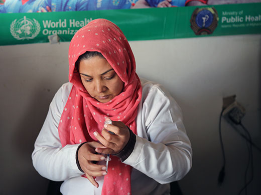 Photo credit: WHO Afghanistan/S.RamoElina prepares the inactivated polio vaccine (IPV) to administer to Maryam, a 3-year-old refugee, at the UNHCR encashment centre in east Kabul. Elina has worked as a vaccinator for 3 years. “The past months have been really busy here, I vaccinated hundreds of children during some of the most hectic days when a lot of families returned,” Elina says. “I am a mother of 3 daughters and really enjoy my job as a nurse and vaccinator. I want to help our children and make sure all Afghan children can be spared from polio paralysis by giving them the polio vaccine.”