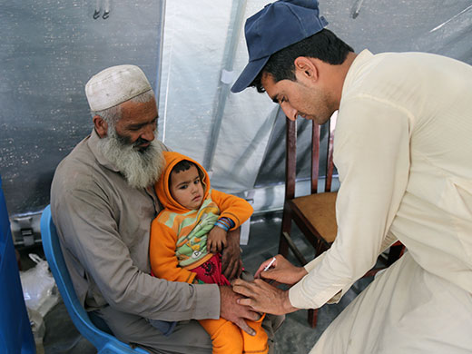 Photo credit: WHO Afghanistan/S.RamoRazi Khan holds his daughter Asma as she gets the injectable inactivated polio vaccine (IPV) at the IOM transit centre near the Torkham border. Razi Khan has 5 daughters and four sons and he has lived in Pakistan for the last 30 years after moving there from Laghman province. “My hope is that my children can go to school and that I manage to find some work as a day labourer,” Razi Khan said while Sharifullah administered IPV for Asma. “I’ve been working as a vaccinator for the past month and a half and I enjoy my job. I don’t want to miss any children and I want to see polio gone from our country,” Sharifullah said.