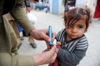 A girl gets her finger marked with ink to show she has received the polio vaccine