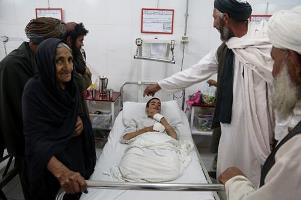 Nazo stands by his grandson at the Emergency Hospital in Helmand