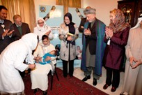 An infant receives a vaccination against pneumococcal disease. To the right of the child Dr Suraya Dalil, the Minister of Public Health and H.E. Hamid Karzai, President of Afghanistan  