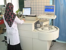 Laboratory technologist working on the Axsym equipment; a machine which tests for serology, hormones & other laboratory parameters