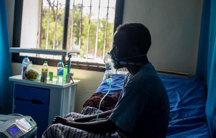 خضع مئات الآلاف من الأشخاص لاختبار فيروس كوفيد-19 بفضل الدعم الذي تقدمه منظمة الصحة العالمية. كما زوَّدت المنظمة المرافق الصحية بالإمدادات الطبية الأساسية، بما يشمل الأكسجين للمرضى مثل هذا المريض في أحد مراكز عزل المصابين بمرض كوفيد-19 في الصومال.