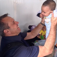 new WHO Regional Emergency Coordinator – Syria crisis Dr Pier Paolo Balladelli with a Syrian baby at a health facility in Al Zaatari camp