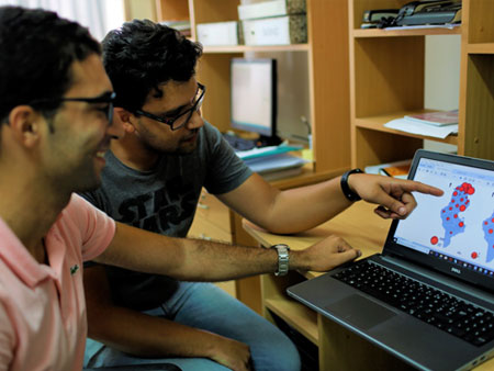 Biostatistician Elyes Boutouria (l) and epidemiologist Wassim Zaatour review Tunisia’s map of influenza sentinel sites at the national observatory for new and emerging diseases 
