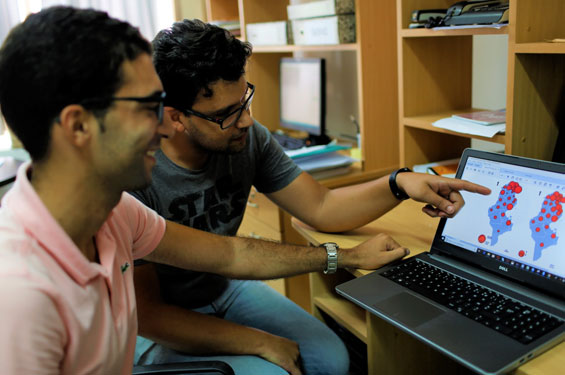 Biostatistician Elyes Boutouria (l) and epidemiologist Wassim Zaatour review Tunisia’s map of influenza sentinel sites at the national observatory for new and emerging diseases (Photo: Simon van Woerden/WHO).