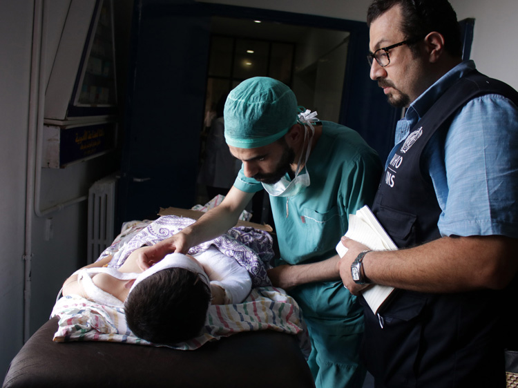 Dr Fares Kady speaks with a surgical resident at Aleppo University Hospital as he checks on a child injured by unexploded ordnance