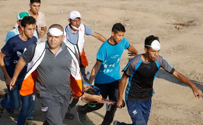 Injured man carried on stretcher during Gaza demonstrations