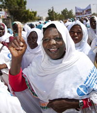Un groupe de femmes d'un certain âge, peau foncée, souriantes, voilées, participent à une marche.