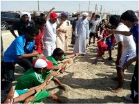 A group of men on the beach involved in physical activity