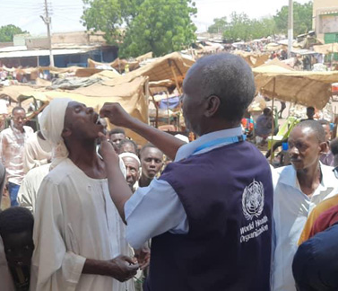 A WHO health worker administers oral cholera vaccine to a resident during a mass vaccination campaign in Sudan, aimed at controlling the recent outbreak and protecting vulnerable communities