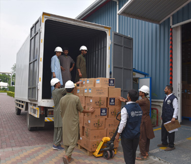 WHO teams load one of the trucks dispatched to preposition essential medical supplies
