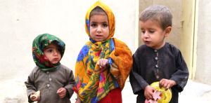Three children show dots of ink on their fingers which show that they were reached with polio vaccines during a polio vaccine on the outskirts of Kandahar city