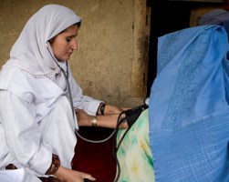 قابلة تفحص ضغط دم المريض في خاسباك، أفغانستان