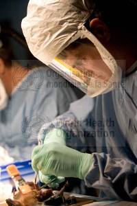 Laboratory technician wearing protective clothing, collecting a specimen