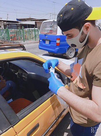 يقوم عباس بتثقيف السائقين الآخرين حول مخاطر والوقاية من COVID-19 في مدينة الصدر ببغداد
