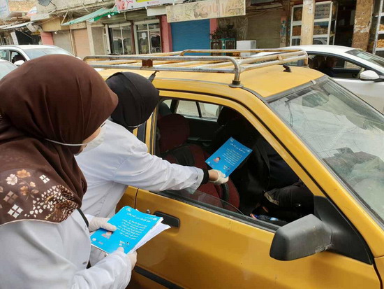عاملون صحيون متنقلون يوزعون رسائل توعوية لمنظمة الصحة العالمية على العامة في إحدى المحافظات العراقية، فبراير 2020. منظمة الصحة العالمية في العراق