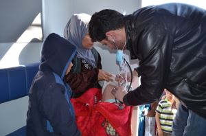 Dr  Yousif Mohammed Ali examines a baby at a mobile medical clinic in Kebirto IDP camp 1 . Photo: WHO/P Ajello