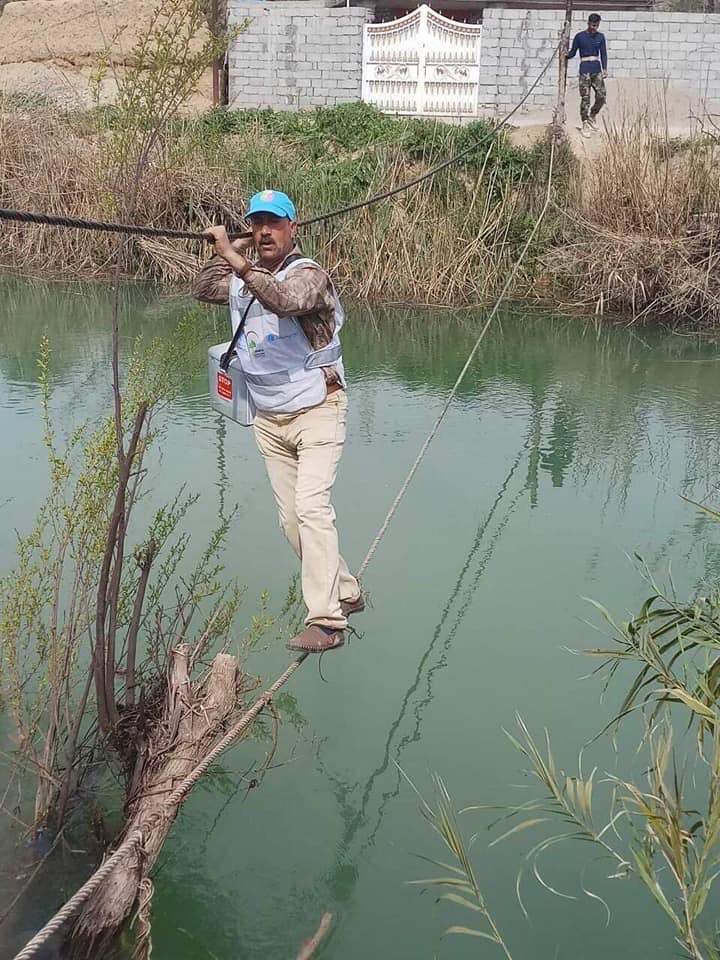 Unsung hero Mowafaq Salem Addai, head nurse at the Muqdadiya sub-health centre of the Diyala Health Directorate, crosses the Khiresan River near Diaba village