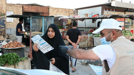 volunteer-_gives-woman-shopping-at-market-in-maysan-brochure