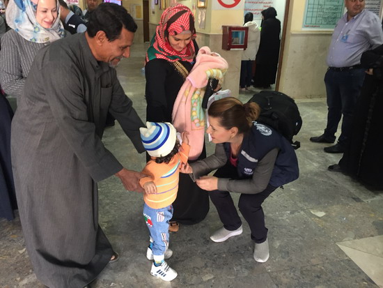 WHO staff member provides reassurance to a young girl after she was vaccinated