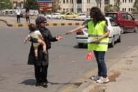 WHO partner volunteer distributes advocacy materials to a pedestrian road user