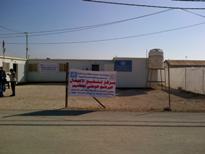 WHO caravan in Zaatari camp, with a banner advertising the free immunization treatments for children every Wednesday and Saturday between 9am and 1pm.