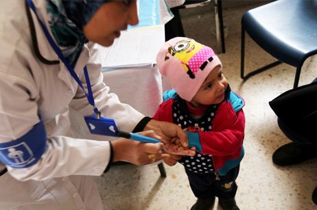 Children in a Jerash health centre have their fingers marked for vaccination verification purposes after receiving two drops of oral polio vaccine. Photos: WHO/J.Swan