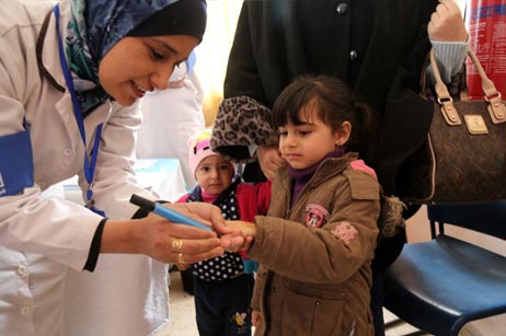 Children in a Jerash health centre have their fingers marked for vaccination verification purposes after receiving two drops of oral polio vaccine. Photos: WHO/J.Swan