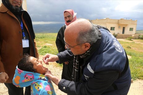 WHO’s Dr Osama Mere vaccinating a child in a high-risk area during a mobile clinic visit