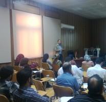 A photograph of a trainer teaching a group of trainees in a classroom