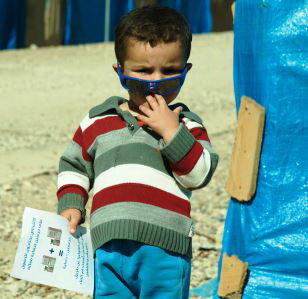 Boy holds information leaflet during cholera campaign in Iraq
