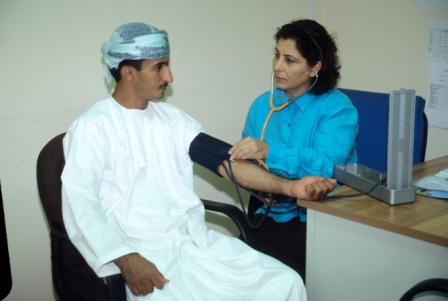 A female nurse in Oman testing the blood pressure of a male patient