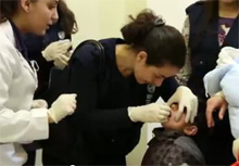 A doctor administers oral polio vaccine to a young child