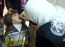 A Syrian child receives polio vaccine during the campaign