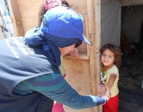 موظفة بمنظمة الصحة العالمية تتفاعل مع طفلة عراقية