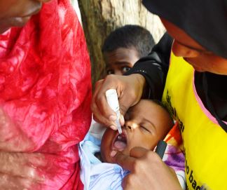 A child receives just two drops in the mouth of the poilio vaccine during a vaccination campaign