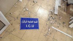A sign for the intensive care unit lies on the floor of a damaged hospital