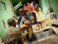 A Somali woman hands her severely malnourished child to a medical officer of the African Union Mission in Somalia. 