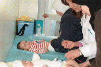 Health staff immunize a child against polio in a health clinic in Damascus