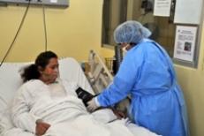 Une infirmière s'occupe d'une patient asthmatique couchée sur son lit d'hôpital